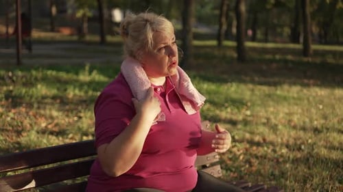 Grosse femme se reposant après avoir couru