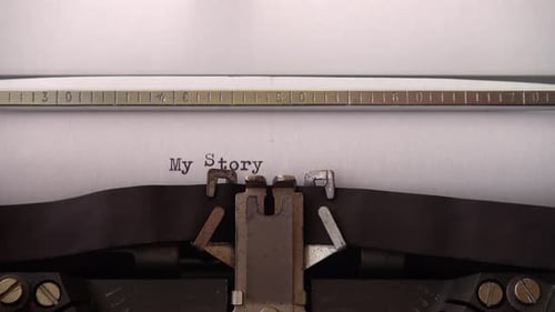 Typing phrase My Story on retro typewriter. Close up.