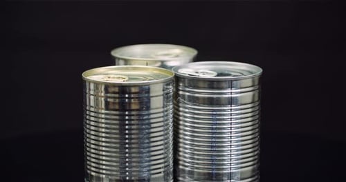 Three Metal Food Cans on Black Background