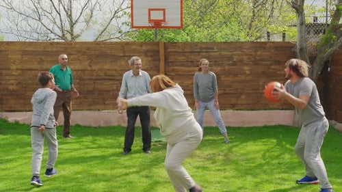 Family Playing with a Basketball in the Back Yard.