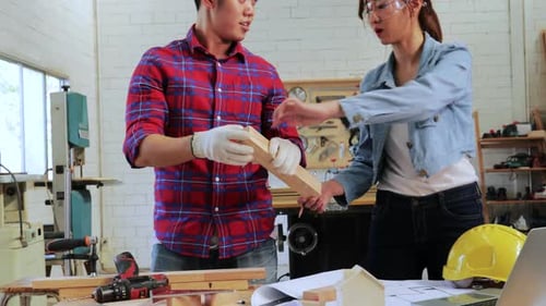 Two Architect designing wood construction project on drawing paper in workshop