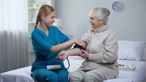 Nurse Taking Blood Pressure of Senior Woman