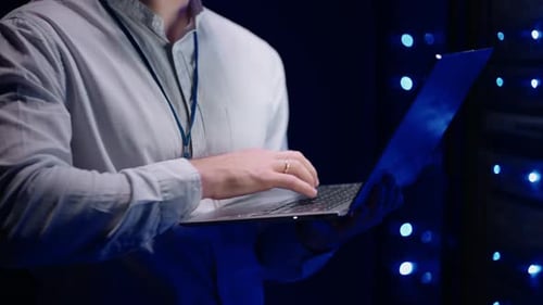 Man Holding Laptop in Data Center Server Room