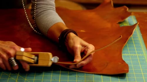 Close-up of craftswoman cutting leather