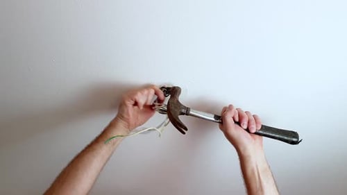 Man Hammers Nail into Ceiling Electrical Wires