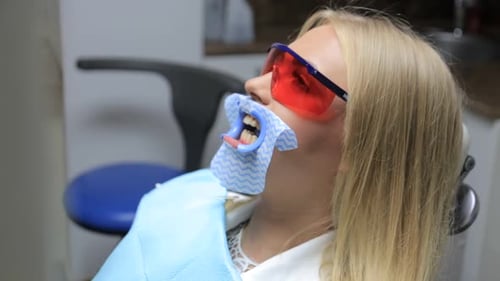 Teeth whitening procedure, dentist - Close-up of patient