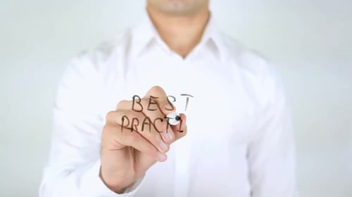 Man Writes Best Practice on Clear Surface