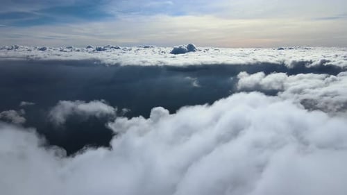 Aerial View From Airplane Window at High Altitude of Earth Covered with Puffy Cumulus Clouds Forming