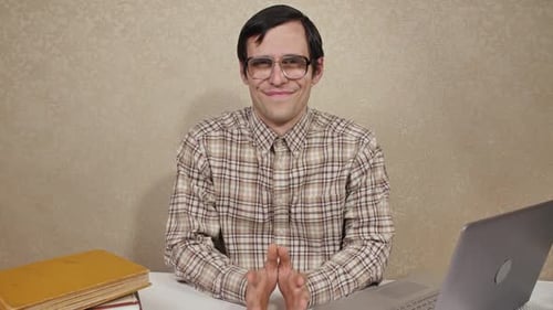 Man Smiling at Desk With Laptop and Books