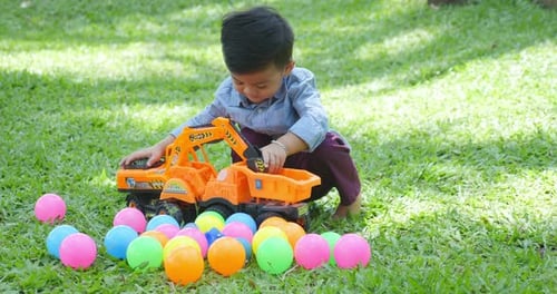 Boy Plays with Construction Toys in Grassy Yard