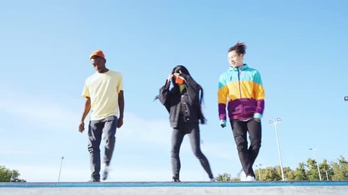 Three Young Adults Dancing Together Outdoors