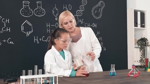 Child and Teacher Conduct Science Experiment in Lab