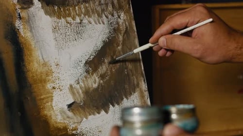 Close-up of Artist Hand, Holding Paint Brush and Drawing Gloomy Picture. Contemporary Painter