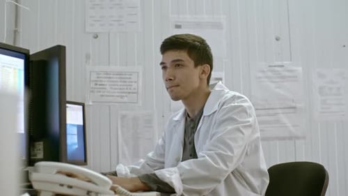 Young Adult Working at Computer in Office