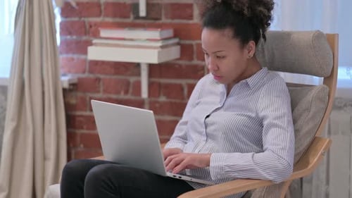 African American Woman with Laptop Reacting to Loss