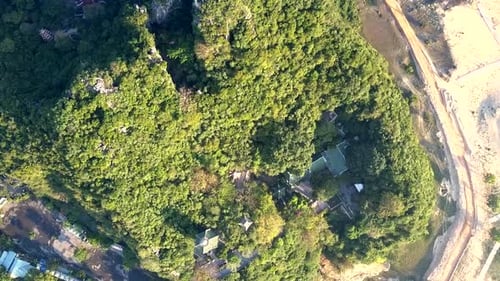 Drone Hangs Over Temple Buildings on Green Hill at Road