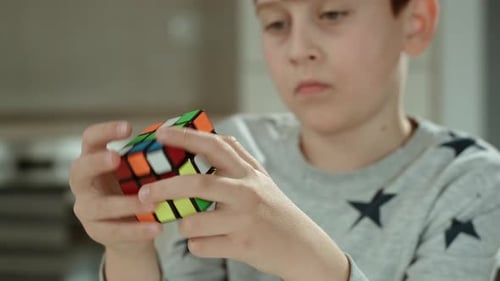 Young Boy Solving Colorful Rubik's Cube Puzzle