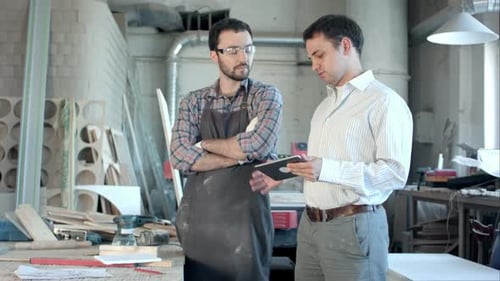 Boss Shows Something To Carpenter on the Tablet