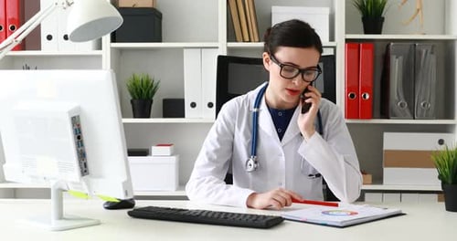 Woman Doctor Talking on Phone in Office