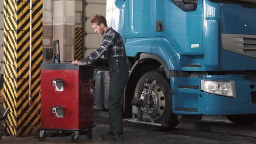 Mécanicien utilisant un ordinateur portable près du compartiment moteur de la voiture