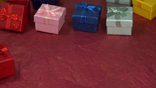 Colorful Small Gift Boxes on Textured Red Background