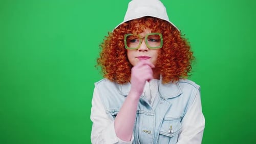 Young Nervous Redhead Woman in Eyeglasses and Panama Hat Biting Her Fingers Hugging Herself Over