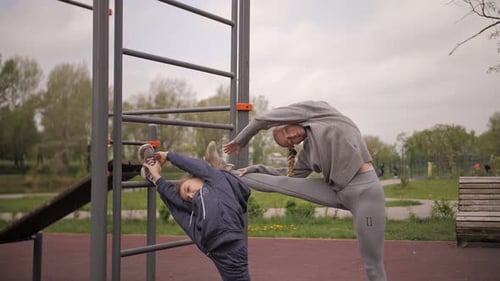 Mother and Daughter Doing Exercises on Open Air Sport Playground