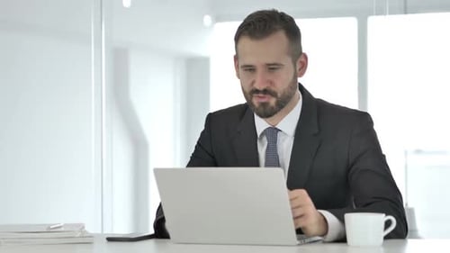 Young Adult Man Working on Laptop in Office