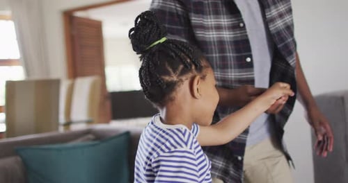 Playful Child Dancing with Man in Bright Home