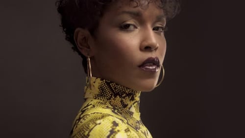 Femme afro-américaine en robe jaune vif à imprimé python