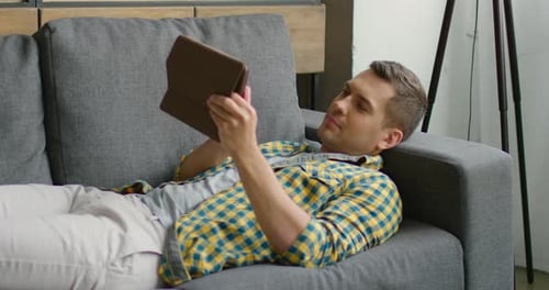 Man Relaxing on Couch with Tablet Indoors