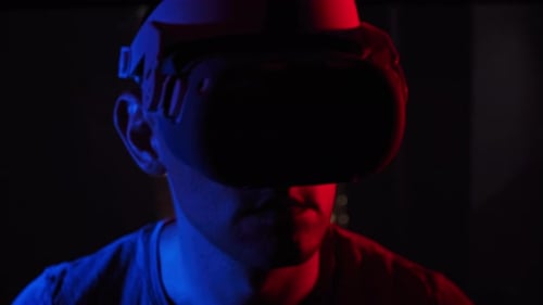 Man Wearing Virtual Reality Headset in Dim Lit Room