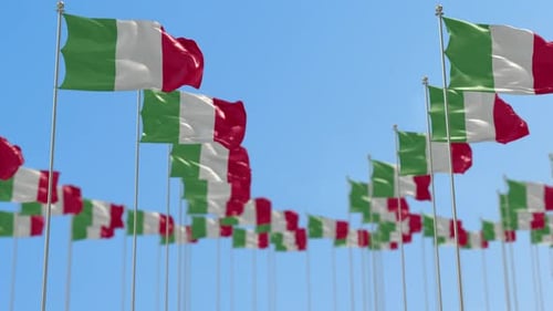 Multiple Italian Flags Waving in Wind Against Clear Blue Sky