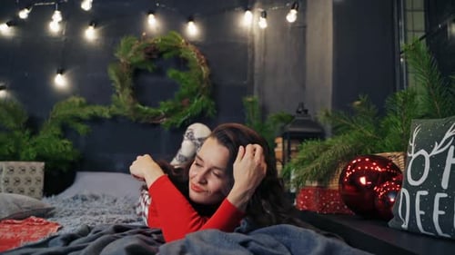 Woman Relaxes with Christmas Decorations in Cozy Setting