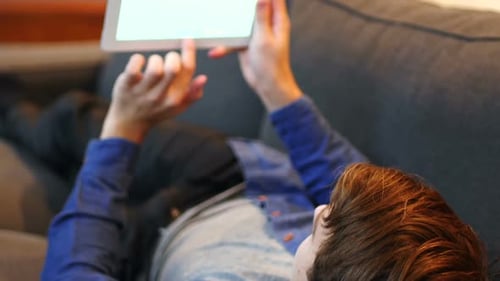 Young Adult Drawing on Tablet While Lying Down