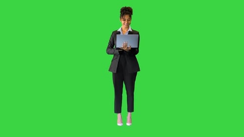 Young African American Employee Working on a Laptop on a Green Screen Chroma Key