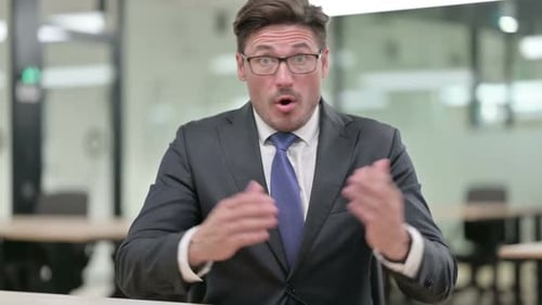 Surprised Businessman Reacts to News in Office