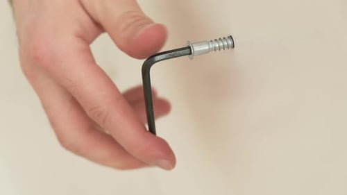 Close Up Man Hands Tighten the Screw on the Furniture