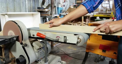 Young Adult Smoothing Wood on Belt Sander