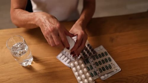 Woman Dispenses Pills from Bottle onto Hand