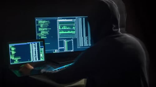 Hooded Hacker Typing in Dark Cyber Environment