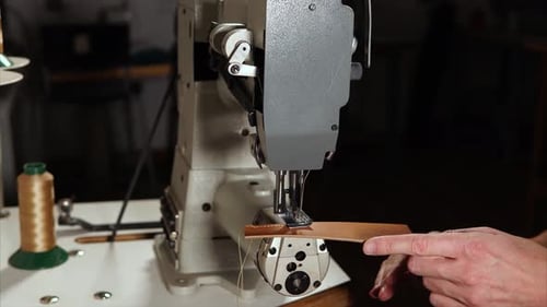 Man operating industrial sewing machine in workshop