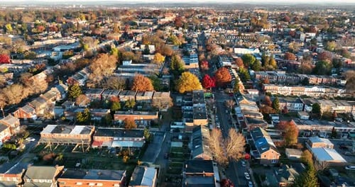 Rising aerial establishing shot of urban American city during fall foliage. Beautiful light.