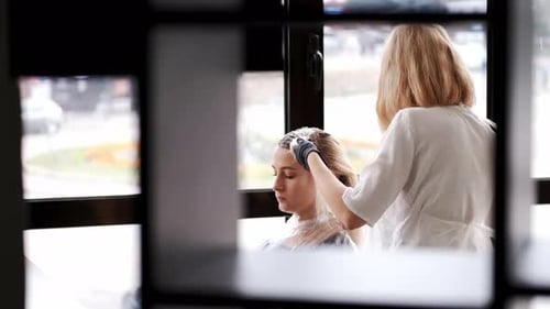 Hair Stylist Applying Treatment in Salon