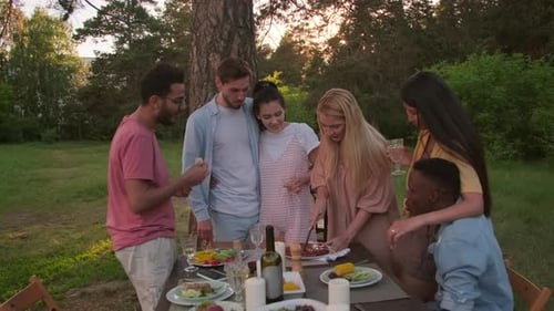 Friends Celebrating Birthday with Outdoor Meal in Park