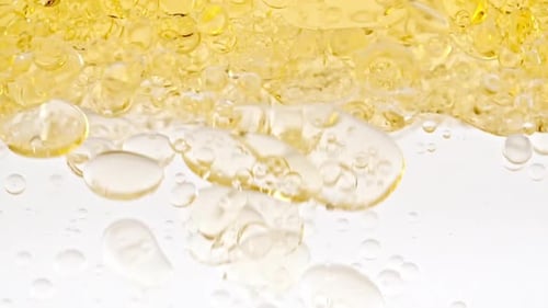 Golden Bubbles Suspended in Clear Liquid