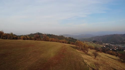 Flight over autumn mountains in the light of the setting sun