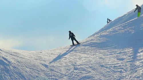 Guys riding snowboards in Alpine mountains, extreme sport