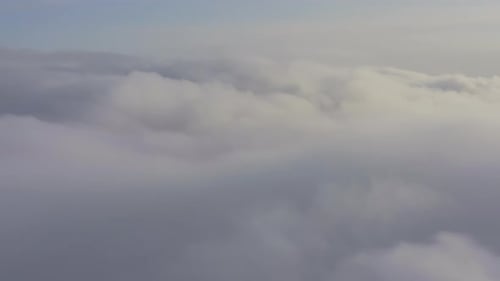 Aerial View Flying Through Cumulus Clouds at Sunset
