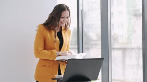 Enthusiastic Woman Waving During Virtual Meeting at Work